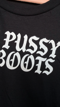 Black t-shirt with ‘LICK PUSSY NOT BOOTS' printed in white text.