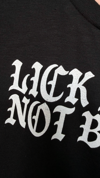 close up detail on the print “lick pussy not boots” hand printed 
