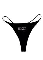Black thong with "Lick Pussy Not Boots" printed small in white gothic letters on the front