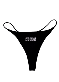 Black thong with "Lick Pussy Not Boots" printed small in white gothic letters on the front