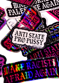 White "Anti State Pro Pussy" sticker with black gothic lettering on a pile of holographic Cuntry Club stickers