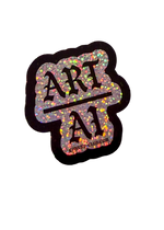 Silver holographic glitter Art Over AI sticker with black gothic lettering and a black border