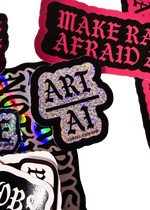 Silver glitter "Art Over AI" sticker, Art above a line and AI below, on a pile of Cuntry Club stickers