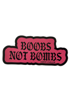 Pink Boobs Not Bombs sticker with black gothic lettering and a black border