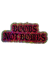 Pink and silver glitter Boobs Not Bombs sticker with black gothic lettering