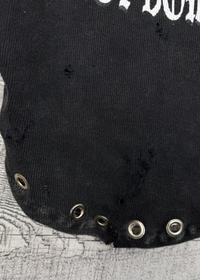 Black sleeveless top with grommets on a textured surface