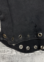 Black garment with metallic buttons on a textured surface