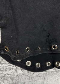 Black garment with metallic buttons on a textured surface