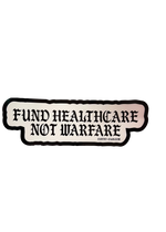 White Fund Healthcare Not Warfare sticker with black gothic lettering and a black border