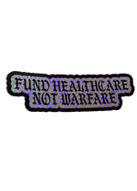Silver glitter Fund Healthcare Not Warfare sticker with black gothic lettering