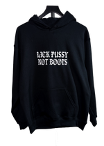 A black pullover hoodie hanging on a black hanger against a plain white background, featuring the phrase 'LICK PUSSY NOT BOOTS' printed in a white gothic font across the chest.