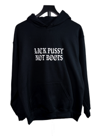 A black pullover hoodie hanging on a black hanger against a plain white background, featuring the phrase 'LICK PUSSY NOT BOOTS' printed in a white gothic font across the chest.