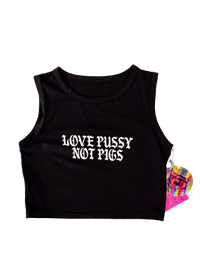 Black cropped tank top laid flat with "Love Pussy Not Pigs" in white gothic letters and a pink hangtag