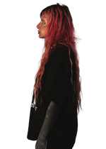 alternative femme with piercings, tattoos and split dye hair wearing a boxy oversized "ruin rapists' lives" tee from the left side
