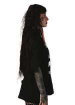 alternative femme with piercings, tattoos and split dye hair wearing a boxy oversized "ruin rapists' lives" tee from the right side