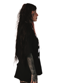 alternative femme with piercings, tattoos and split dye hair wearing a boxy oversized "ruin rapists' lives" tee from the right side