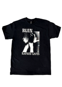 Black t-shirt laid flat with a black and white photo of a figure raising their hands to their face, framed by "Ruin Rapists' Lives" in gothic letters