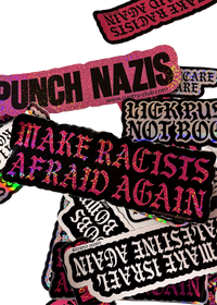 XL black "Make Racists Afraid Again" sticker with pink glitter gothic lettering on a pile of Cuntry Club stickers